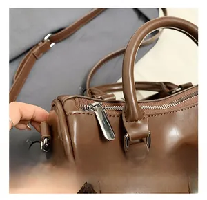 Détails du sac bowling vintage marron montrant la fermeture éclair et les crochets en métal