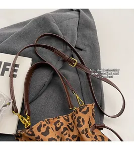 Detail of leopard print bag with adjustable dark brown leather strap and gold metal buckle