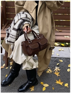 Détail du sac Boston marron foncé avec poches à rabat et poignées en métal argent