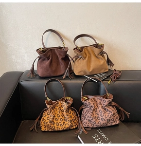 Detail view of four velvet drawstring bucket bags in solid tones and leopard patterns