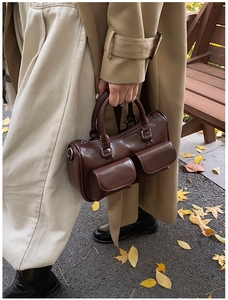 Détail d'un sac bowling marron foncé rétro avec deux poches avant et double poignée