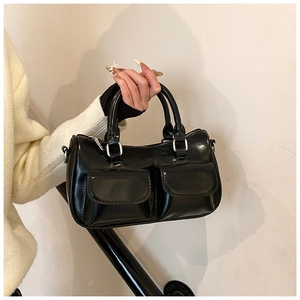 Détail du sac Boston en cuir verni noir avec poches frontales et ferrures argentées