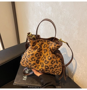 Detail of leopard print bucket bag with leather fringe tassels and drawstring closure