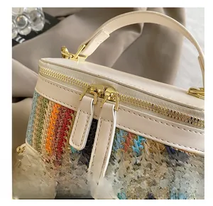 Detail of smooth gold dual zippers on a colorful striped woven handbag
