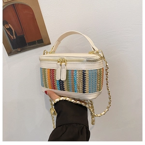 Detail of colorful woven stripes and beige leather handle on the mini box shoulder bag