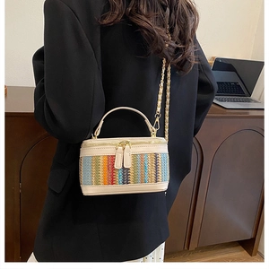 Mini striped box crossbody bag with gold chain strap shown on black blazer shoulder