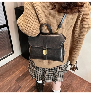 Detail of vintage flap crossbody bag with gold hardware worn over a warm knit sweater