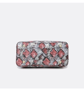Detail view of python pattern handbag base with four protective gold metal feet