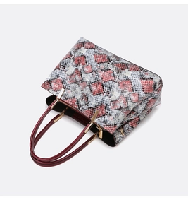 Top view of snake pattern tote bag showing red handles and golden metal hardware