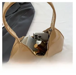 Interior view showing the storage capacity of the camel glossy patent leather handbag