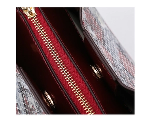 Detail of snakeskin bag showing burgundy lining, golden zipper and magnetic closure