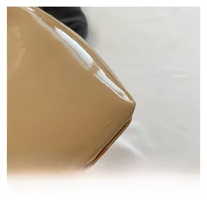 Detailed close-up of premium khaki patent leather handbag showing sleek mirror finish