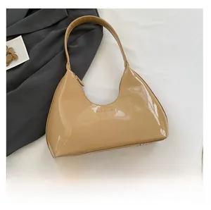 Glossy beige hobo bag with sleek patent finish shown next to a smartphone for size scale