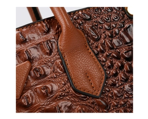 Close-up of brown crocodile texture embossed leather and fine stitching on a handbag
