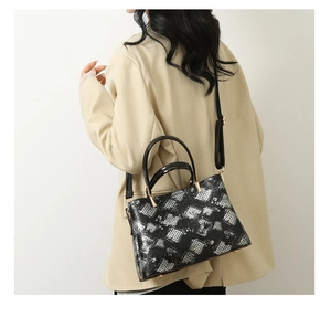 Chic black and white snake skin patterned tote bag carried over a blazer shoulder