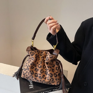 Chic leopard print drawstring handbag with brown leather handles and tassel detail