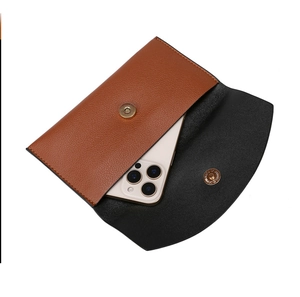 Internal view of the brown leather pouch showing space for a smartphone and magnetic closure