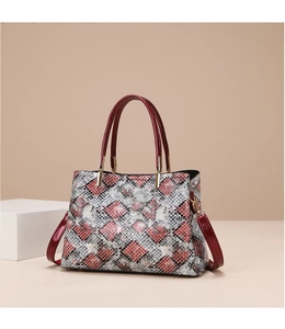 Detail of red and white snakeskin pattern tote with burgundy handles and gold hardware