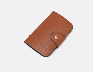 Detail of caramel lychee textured leather mini wallet with golden snap button closure