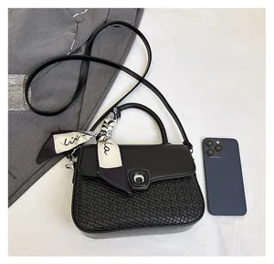 Detail of crossbody bag featuring woven texture, silk scarf handle, and phone size comparison