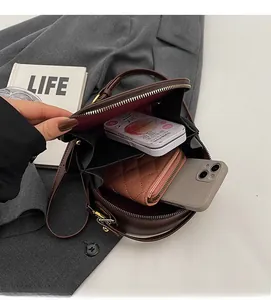 Interior view showing the storage capacity of this brown round leather crossbody bag