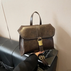 Dark brown leather briefcase with white stitching and brass hardware for commuting