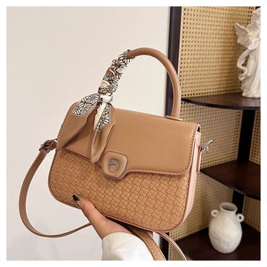 Detail of khaki crossbody bag with woven texture, horsebit buckle and scarf-wrapped handle