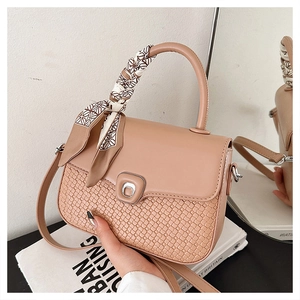 Detail of beige woven leather handbag with silk scarf handle and silver hardware
