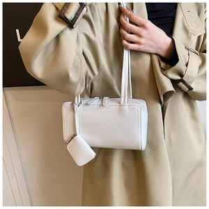 Minimalist cream white shoulder bag with matching mini coin purse detail shown on model