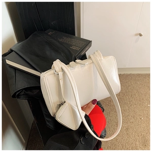 Detail of white glossy leather shoulder bag with matching mini square coin purse attachment
