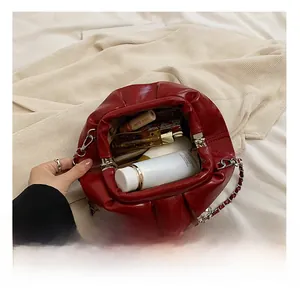 Draufsicht auf das Innere der roten Falten-Clutch mit Kette zeigt geräumigen Stauraum