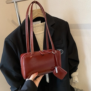 Glossy dark red leather shoulder bag with sleek rectangular shape and matching mini pouch