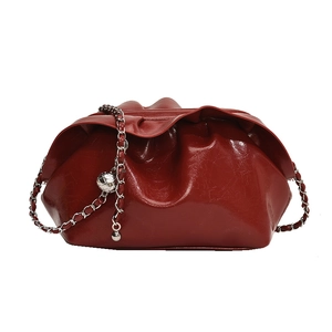 Dunkelrote Falten-Clutch aus Leder mit Silberkette und dekorativer Metallkugel