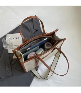 Top view of canvas tote interior showing spacious storage for tablet, umbrella, and phone