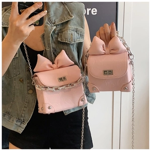 Details einer rosa Mini-Boxtasche mit dekorativer 3D-Schleife und silbernem Metallverschluss