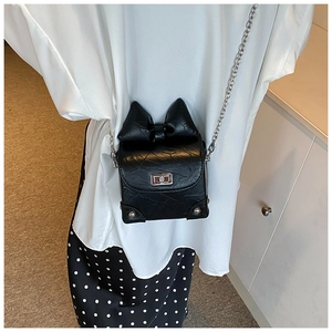 Detail van zwarte mini-crossbodytas met strikontwerp, geplooid leer en zilveren draaisluiting