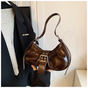 Detail of dark brown glossy leather crescent bag with pleated texture and metal buckle