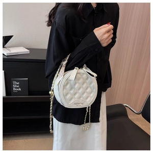 Détail du sac bandoulière rond blanc avec motif matelassé et poignée en foulard