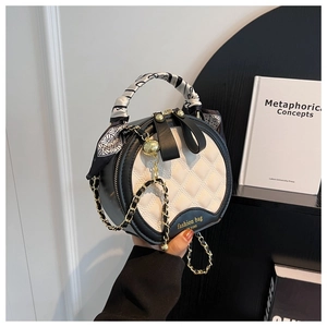 Détail du sac rond matelassé avec poignée en foulard et bandoulière chaîne