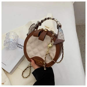 Détail du sac à main rond matelassé avec poignée foulard et bandoulière chaîne dorée