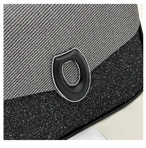 Detail of grey twill denim and black glitter texture with shield-shaped metal lock