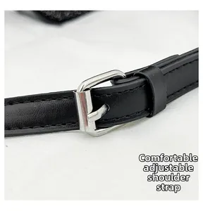 Close-up of adjustable black shoulder strap with silver buckle for crossbody bag