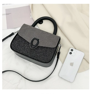 Detail shot of the two-tone contrast bag with matte glitter finish and oval ring buckle