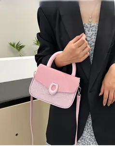 Detail of pink patchwork crossbody bag featuring silver magnetic clasp and top handle