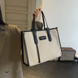Large canvas tote bag with black leather trim and double handles for women's daily use