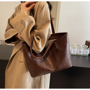 Detail of dark brown faux leather tote bag with vintage oil-wax texture and dual shoulder straps