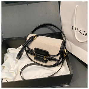 Detail of high-quality canvas saddle bag with black leather trim in premium gift box