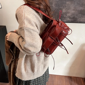 Sac à dos en cuir verni rouge foncé avec rubans décoratifs et design rétro