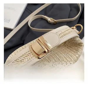 Detailed close-up of premium gold metallic buckle on a woven cream crossbody handbag