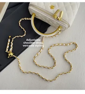 Detail der weißen gesteppten Umhängetasche mit verstellbarer Goldkette und Metallgriff